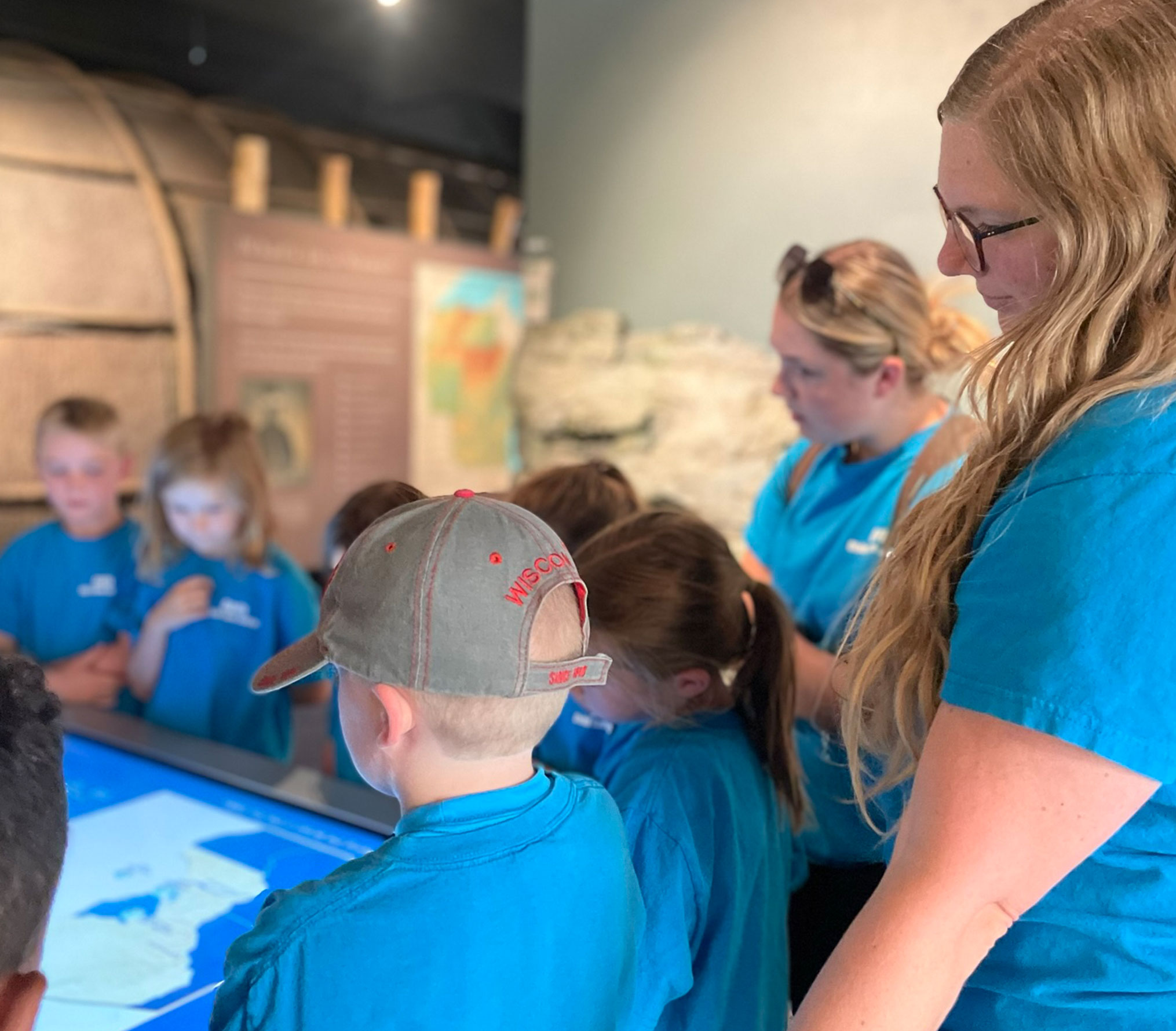 A class on a field trip interacting with a People of the Waters kiosk