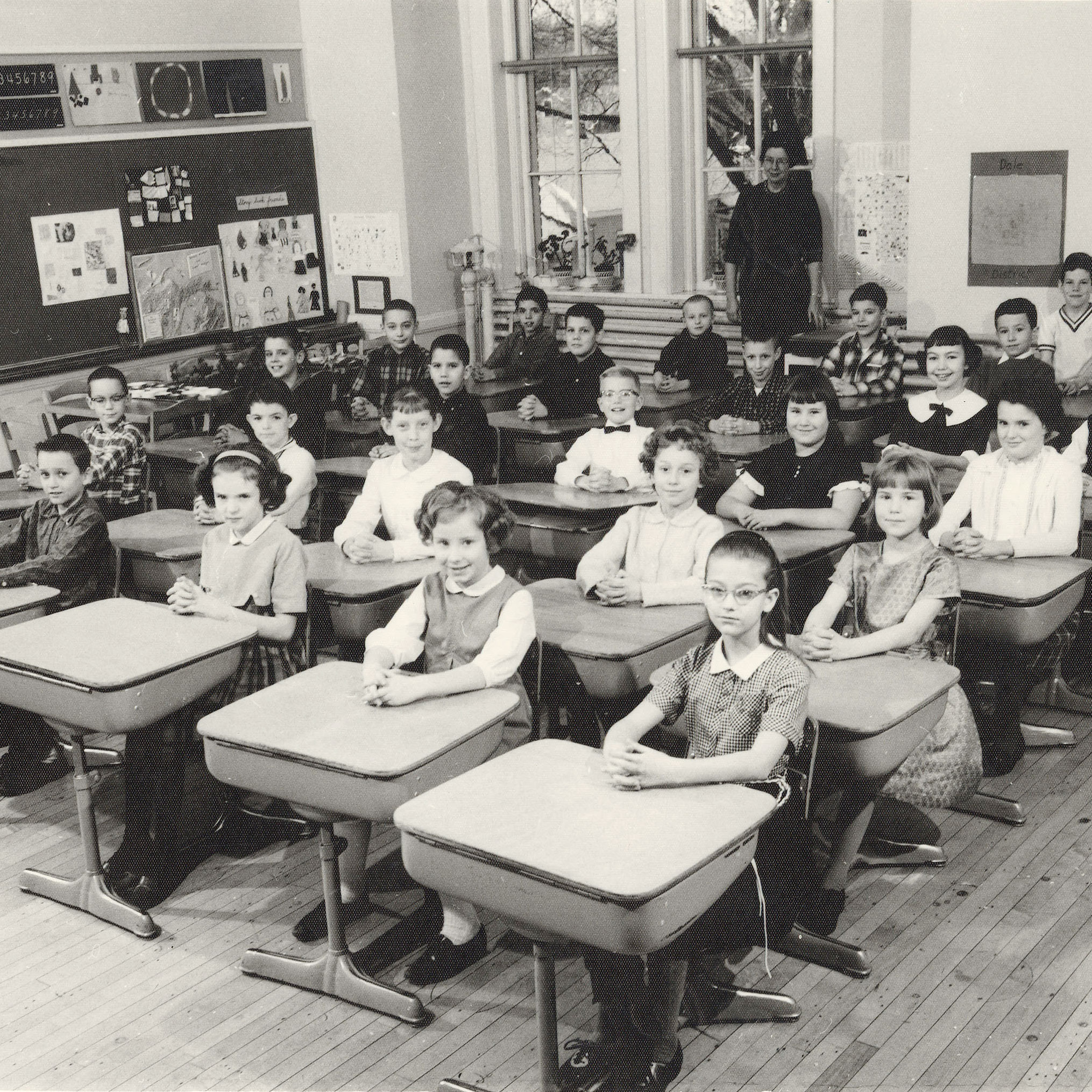 Historic, black and white photo on view in Ever Changing, Ever Oshkosh picturing students seated at their desks in a classroom